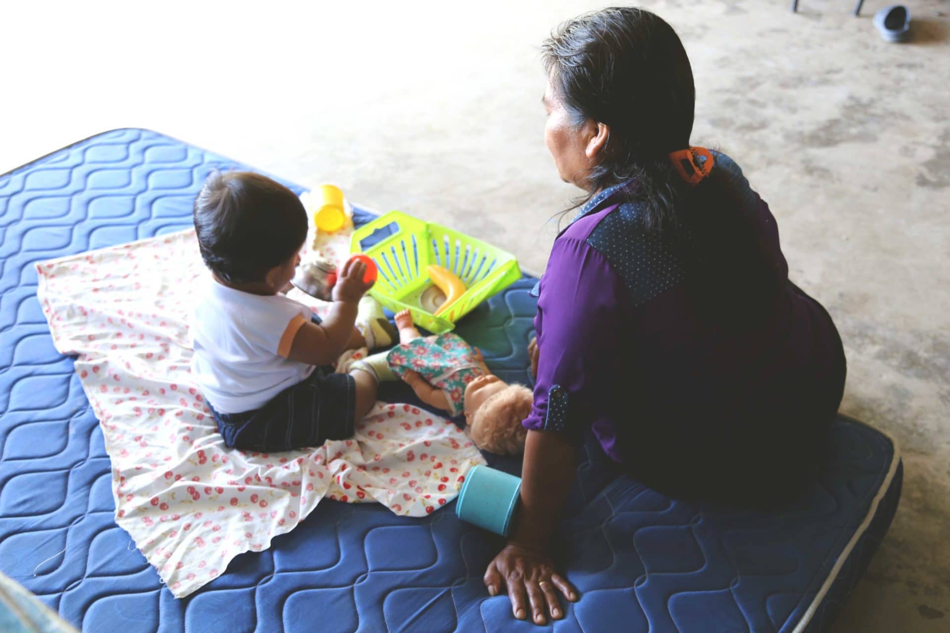 Caregiver with child on blanket